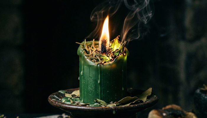 Green_candle_burning_with_herbs_202607240011-e1784862720398.jpeg