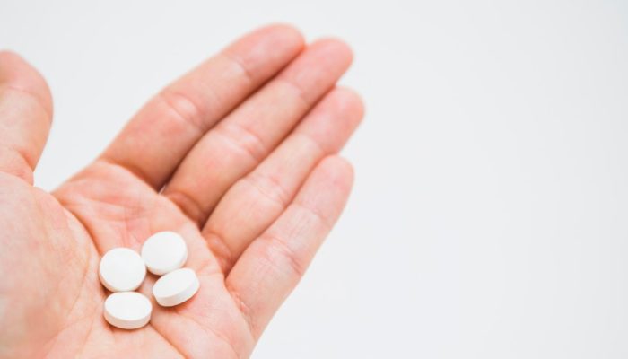 comprimidos-brancos-redondos-na-mao-sobre-o-fundo-branco.jpg
