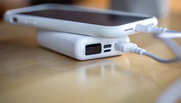 el-telefono-inteligente-se-carga-desde-un-pequeno-banco-de-energia-blanco-traves-de-un-cable-de-cerc.jpeg