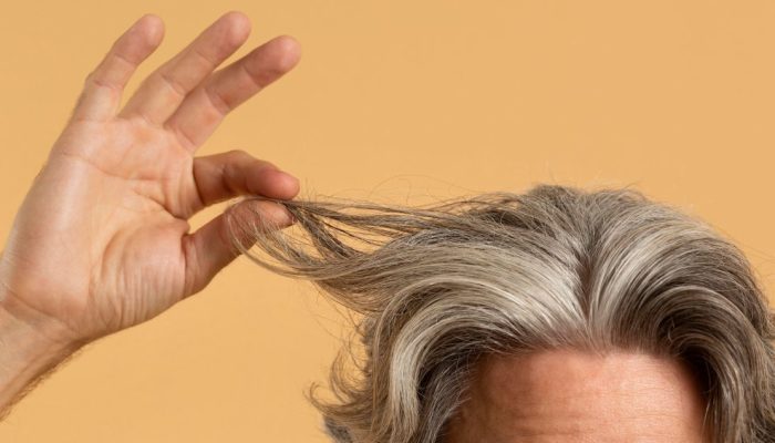 elder-man-holding-his-gray-hair.jpg