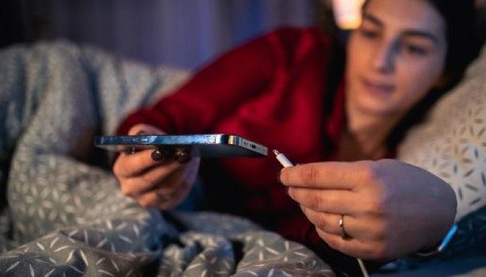 mulher-mexendo-no-celular-enquanto-carrega-celular-carregador-cama-iphone-dormir-1709825377397_v2_61.jpeg