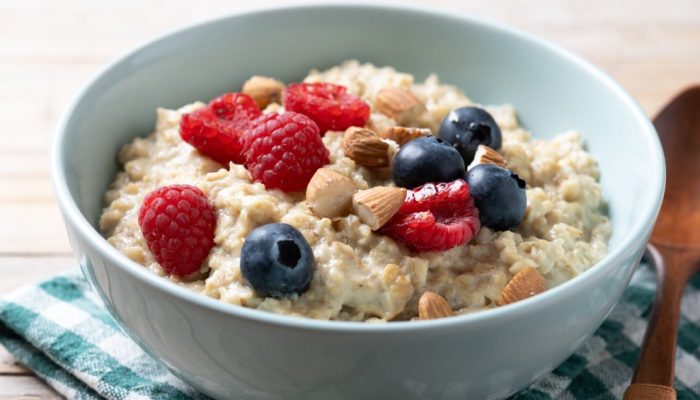 porridge-de-aveia-com-framboesas-mirtilos-e-amendoas-em-uma-tigela-em-uma-mesa-de-madeira.jpg