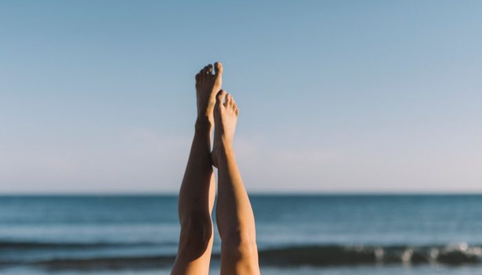 woman-stretching-legs-lying-beach.jpg
